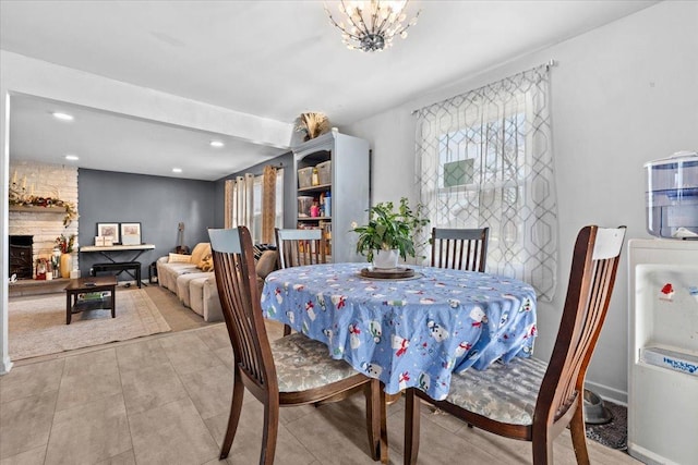 dining space with a fireplace and a notable chandelier