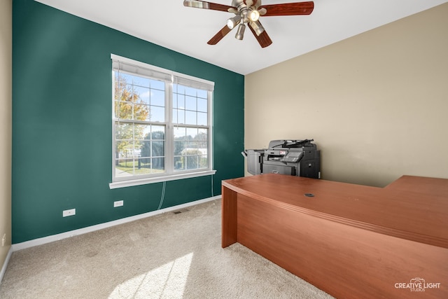 carpeted office space featuring ceiling fan