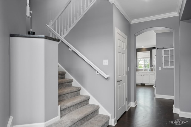 stairs featuring hardwood / wood-style floors, a barn door, and ornamental molding