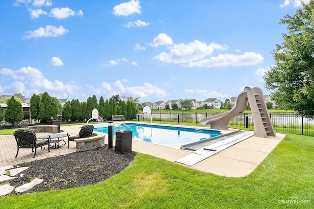 view of swimming pool with a lawn, a patio area, and a water slide