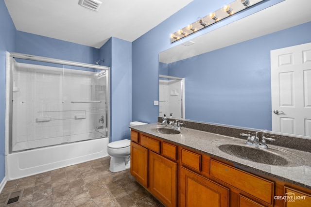 full bathroom with vanity, enclosed tub / shower combo, and toilet