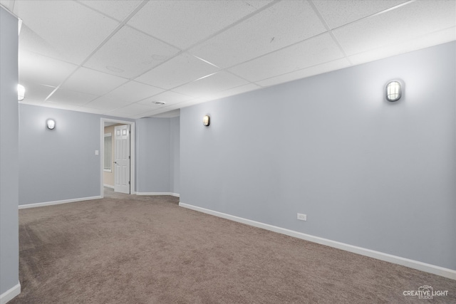 basement featuring a paneled ceiling and carpet flooring