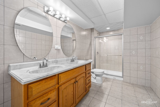 bathroom with tile patterned floors, a shower with shower door, and tile walls