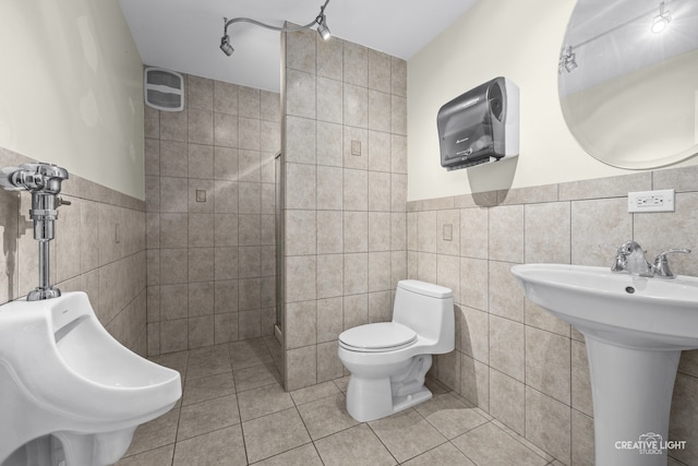 bathroom featuring tile patterned floors, a shower, tile walls, and toilet