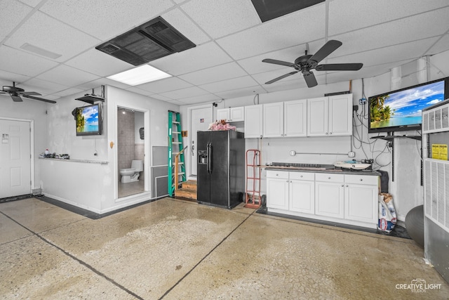 garage with ceiling fan and black fridge