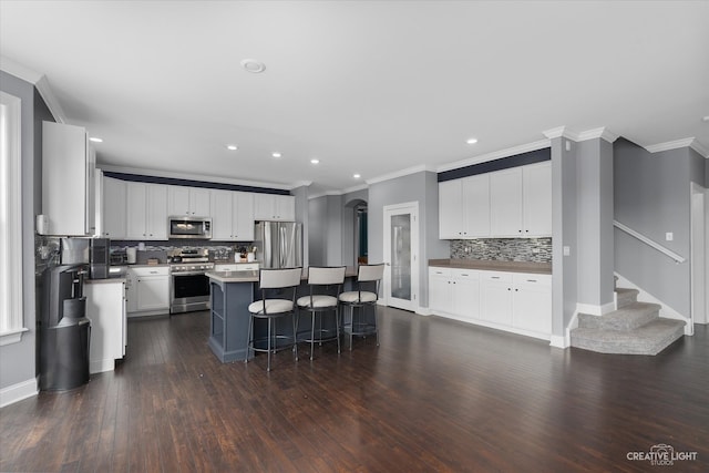 kitchen featuring white cabinets, dark hardwood / wood-style flooring, a center island, and stainless steel appliances