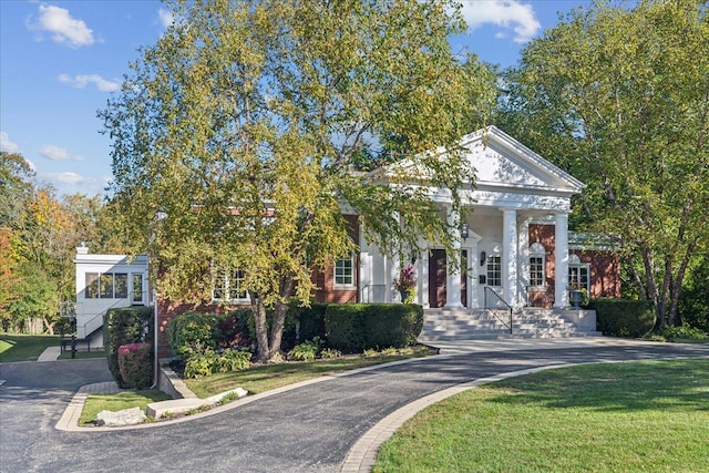 greek revival inspired property featuring a front lawn