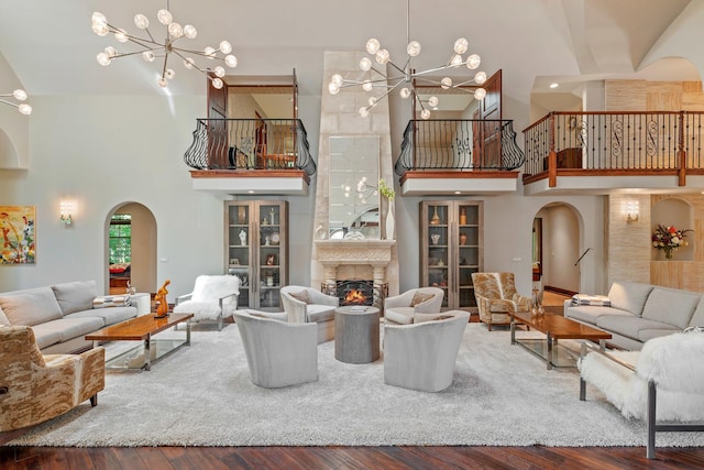 living room with hardwood / wood-style flooring, a notable chandelier, and a towering ceiling