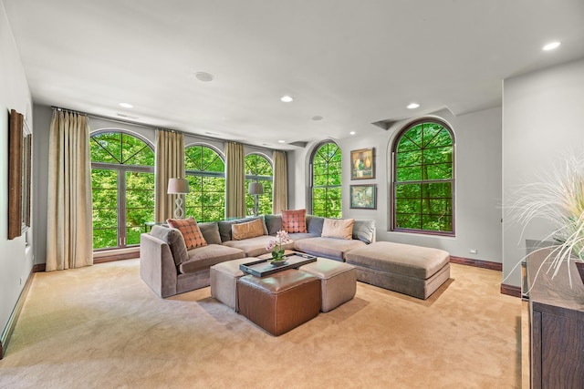 living area with recessed lighting, light colored carpet, and baseboards