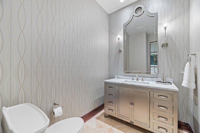 bathroom with tile patterned flooring, toilet, vanity, and wallpapered walls