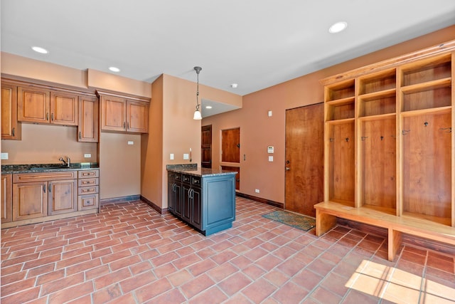 kitchen featuring hanging light fixtures, brown cabinetry, recessed lighting, and baseboards