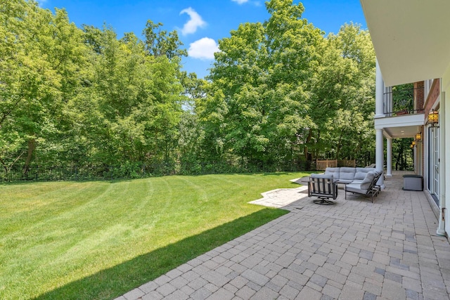 view of yard with a balcony, outdoor lounge area, a patio, and fence