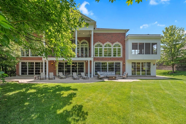 rear view of house featuring a yard, a patio, brick siding, and outdoor lounge area