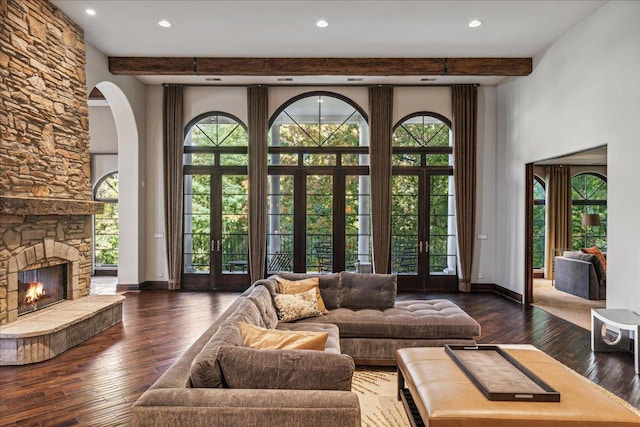 living area featuring beamed ceiling, baseboards, and hardwood / wood-style floors