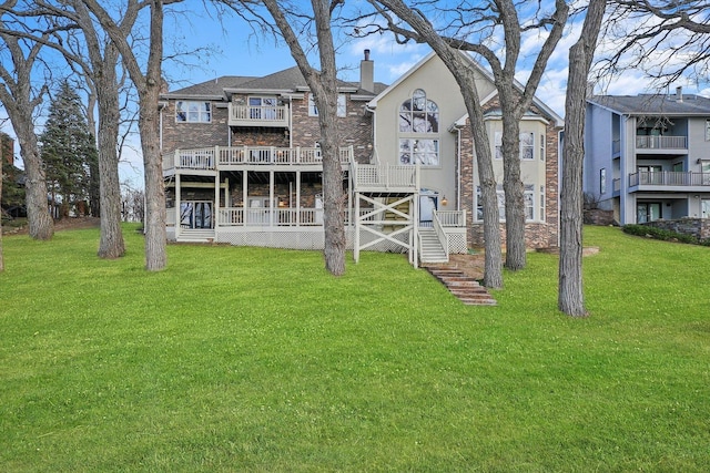 rear view of house with a lawn and a balcony