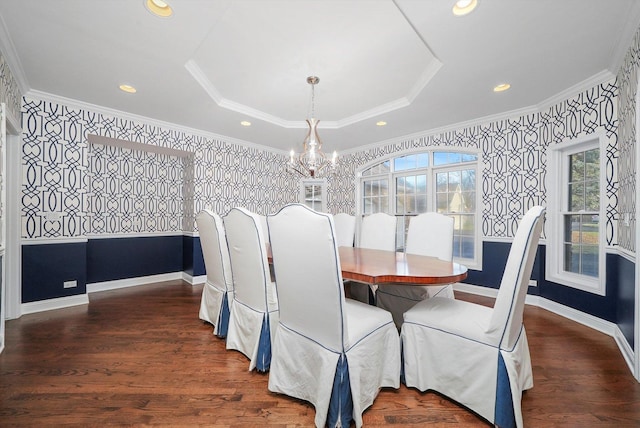 dining room featuring dark hardwood / wood-style flooring, a raised ceiling, crown molding, and an inviting chandelier