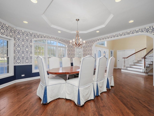 dining area featuring dark hardwood / wood-style flooring, ornamental molding, and a tray ceiling