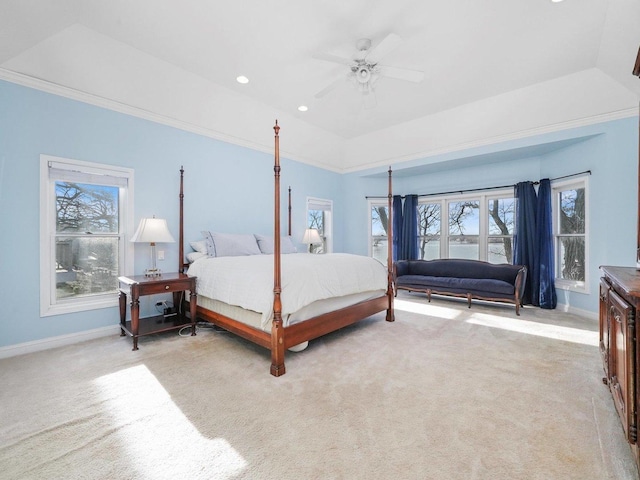 carpeted bedroom with ceiling fan and a raised ceiling