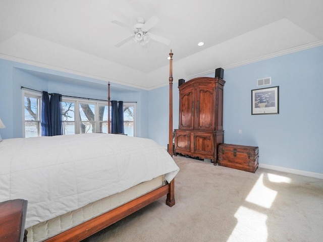 carpeted bedroom with ceiling fan and a tray ceiling