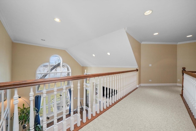 corridor with carpet, ornamental molding, and vaulted ceiling