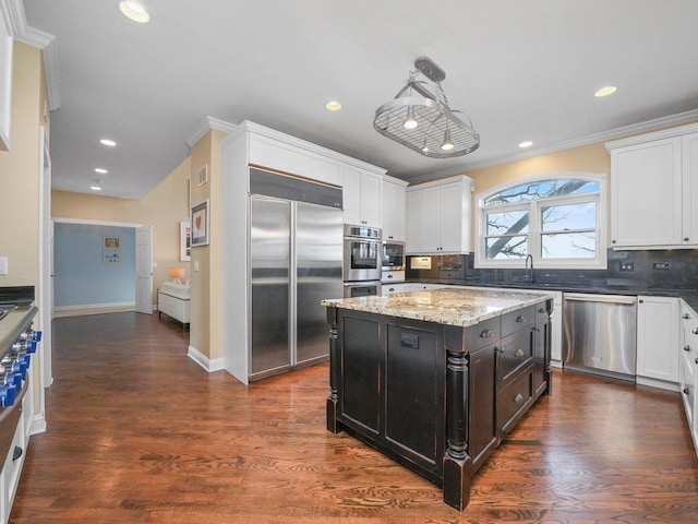 kitchen featuring pendant lighting, backsplash, a kitchen island, dark hardwood / wood-style flooring, and stainless steel appliances