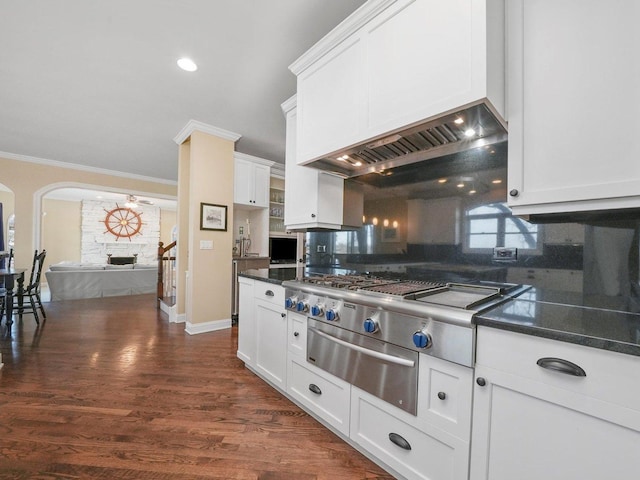 kitchen featuring white cabinets, backsplash, a fireplace, and crown molding