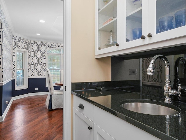 kitchen with white cabinetry, sink, dark wood-type flooring, dark stone counters, and ornamental molding