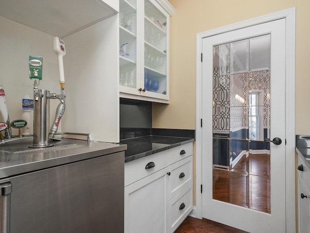 kitchen featuring dark stone countertops and white cabinetry