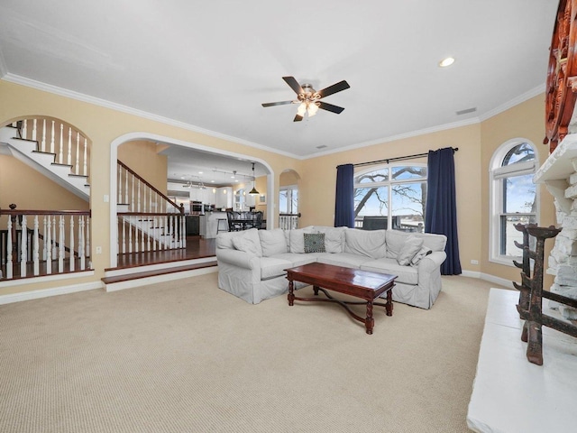 carpeted living room featuring crown molding and ceiling fan