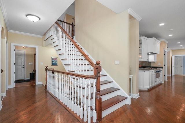 stairway featuring hardwood / wood-style floors and crown molding