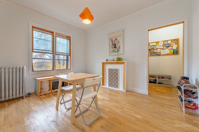 dining area with hardwood / wood-style flooring, radiator heating unit, and ornamental molding