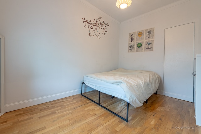 bedroom featuring hardwood / wood-style floors and ornamental molding