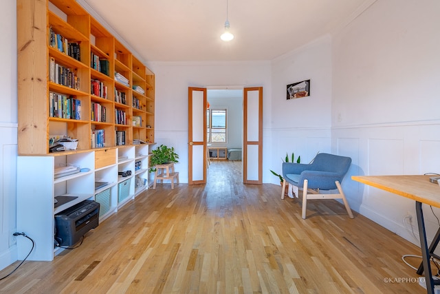 living area featuring french doors, light hardwood / wood-style floors, and ornamental molding