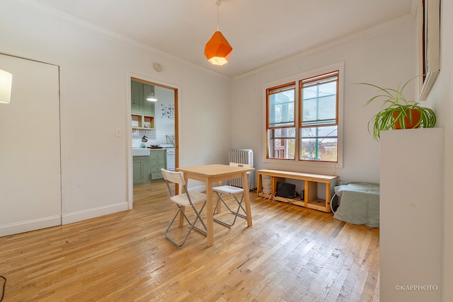 dining room featuring radiator, light hardwood / wood-style floors, and ornamental molding