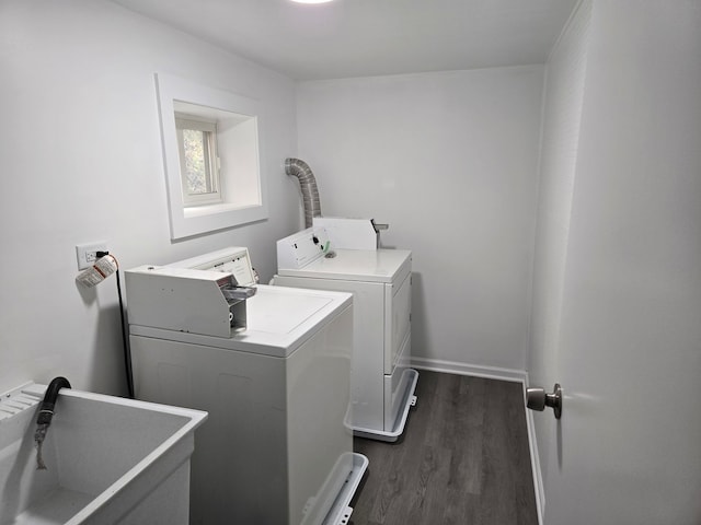 laundry area with sink, washer and dryer, and dark hardwood / wood-style floors