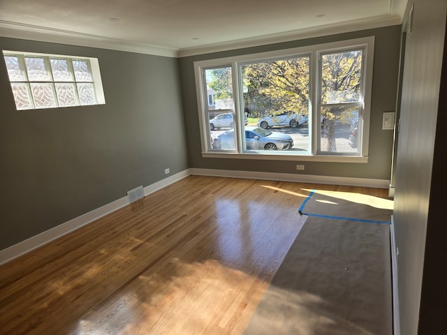 unfurnished room featuring hardwood / wood-style flooring and ornamental molding