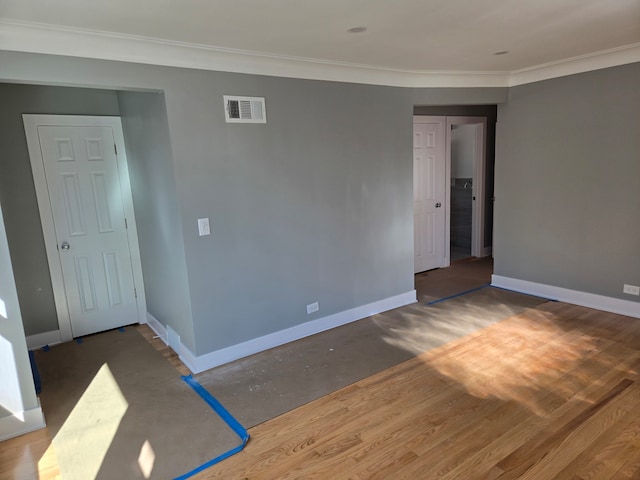 unfurnished room with wood-type flooring and ornamental molding