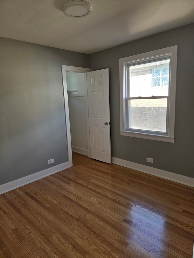 unfurnished bedroom featuring hardwood / wood-style floors and a closet