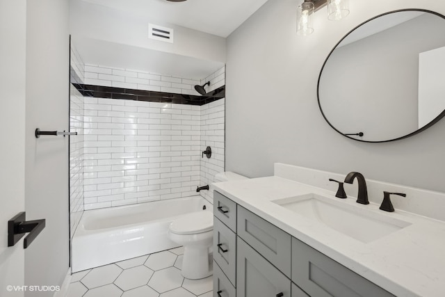 full bathroom with tile patterned floors, vanity, toilet, and tiled shower / bath combo