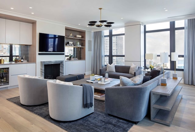 living room with floor to ceiling windows, light wood-type flooring, beverage cooler, and a chandelier