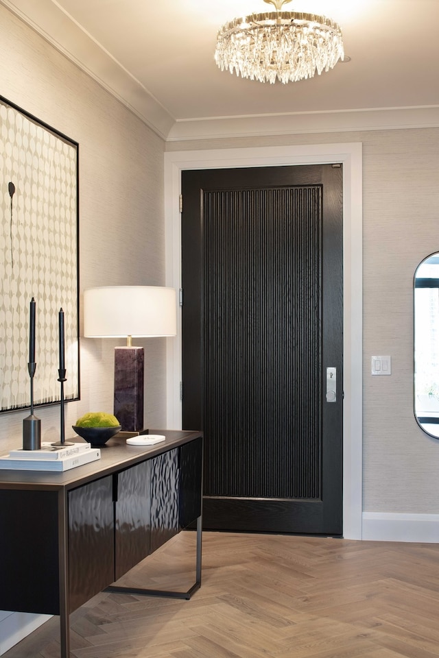 foyer entrance with a chandelier, parquet floors, and ornamental molding