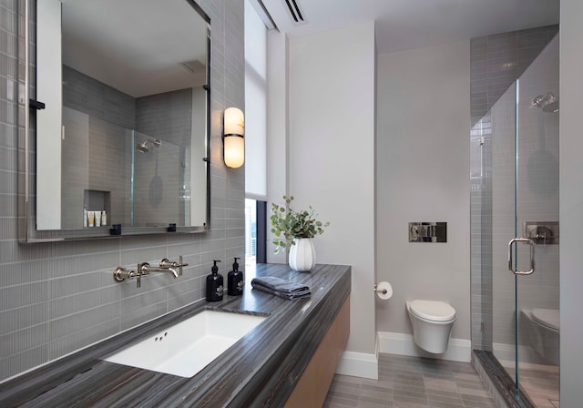 bathroom with vanity, toilet, a shower with shower door, and backsplash