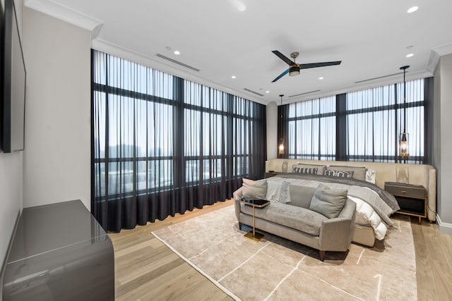 bedroom featuring ceiling fan, light wood-type flooring, a wall of windows, and crown molding