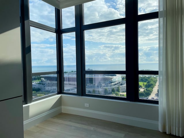 spare room with hardwood / wood-style floors and a water view