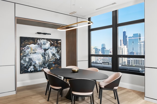 dining room featuring wood-type flooring and an inviting chandelier