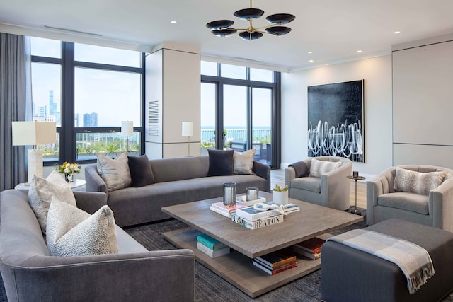 living room with a water view, expansive windows, and a notable chandelier