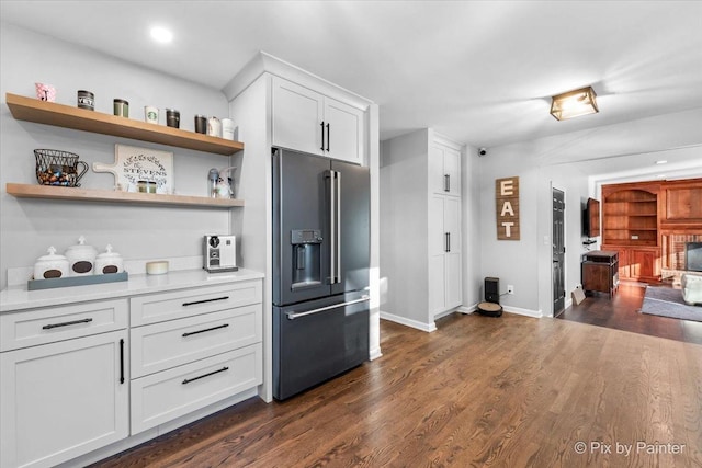 kitchen featuring high quality fridge, white cabinetry, and dark wood-type flooring