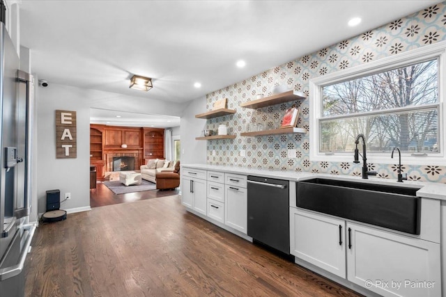 kitchen with stainless steel dishwasher, dark hardwood / wood-style floors, white cabinetry, and sink