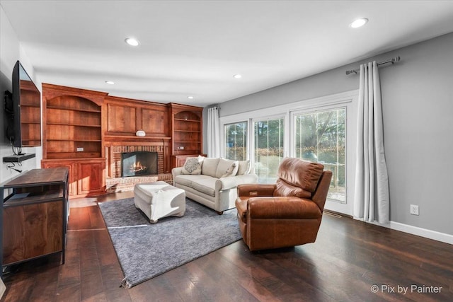 living room with dark hardwood / wood-style floors and a brick fireplace