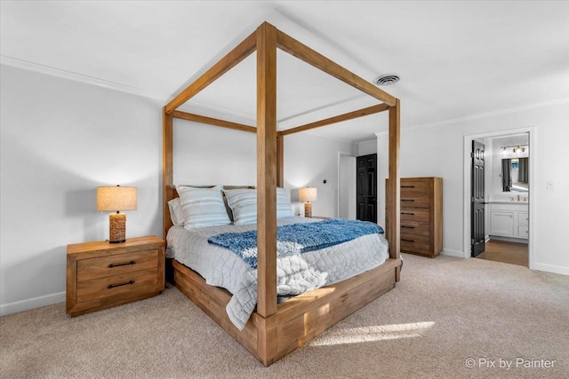 bedroom featuring connected bathroom, light carpet, and crown molding